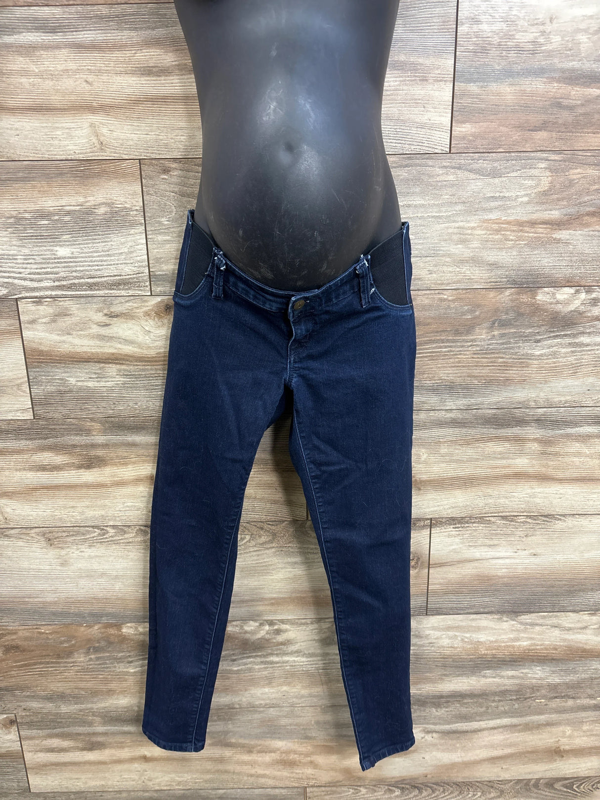 Front view of blue Isabel maternity side-panel jeggings showing elastic side belly panels and skinny legs on wood background