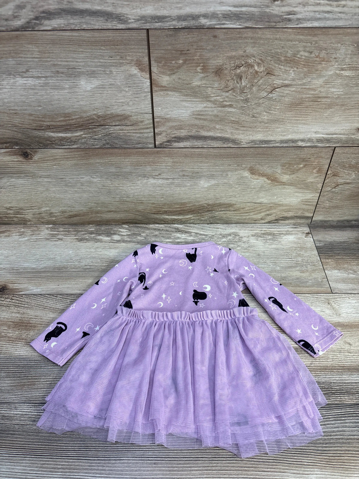 Flat lay of purple long-sleeve baby dress with black cat and moon print and layered tulle skirt, size 6-9 months