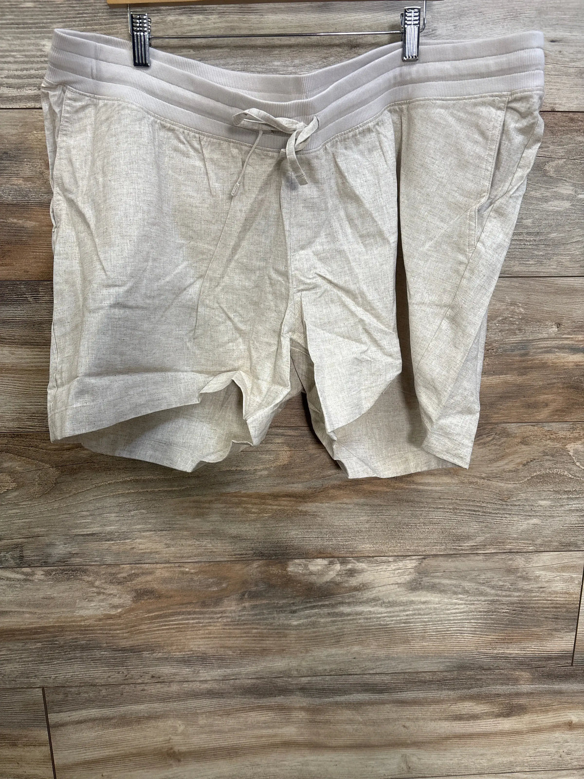Front view of Gap maternity linen-blend shorts showcasing beige fabric, drawcord waist, and front slant pockets on wood floor