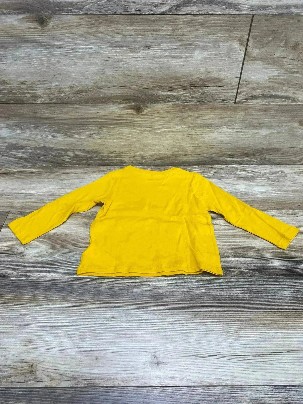 Back view, flat-lay, yellow Old Navy long-sleeve toddler shirt with plain back on wood floor, 18–24 months
