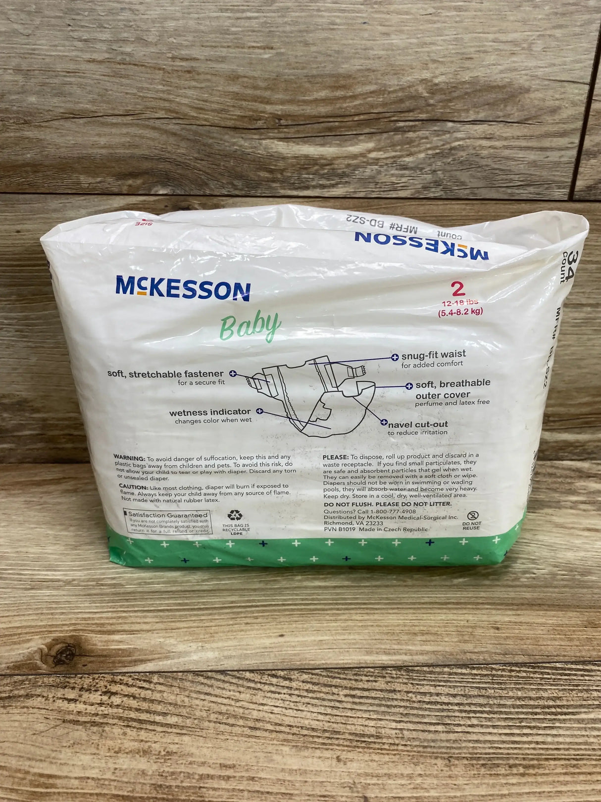 Front view of McKesson Baby Diapers pack, size 2 (34 ct) showcasing wetness indicator and snug-fit waist on wood background