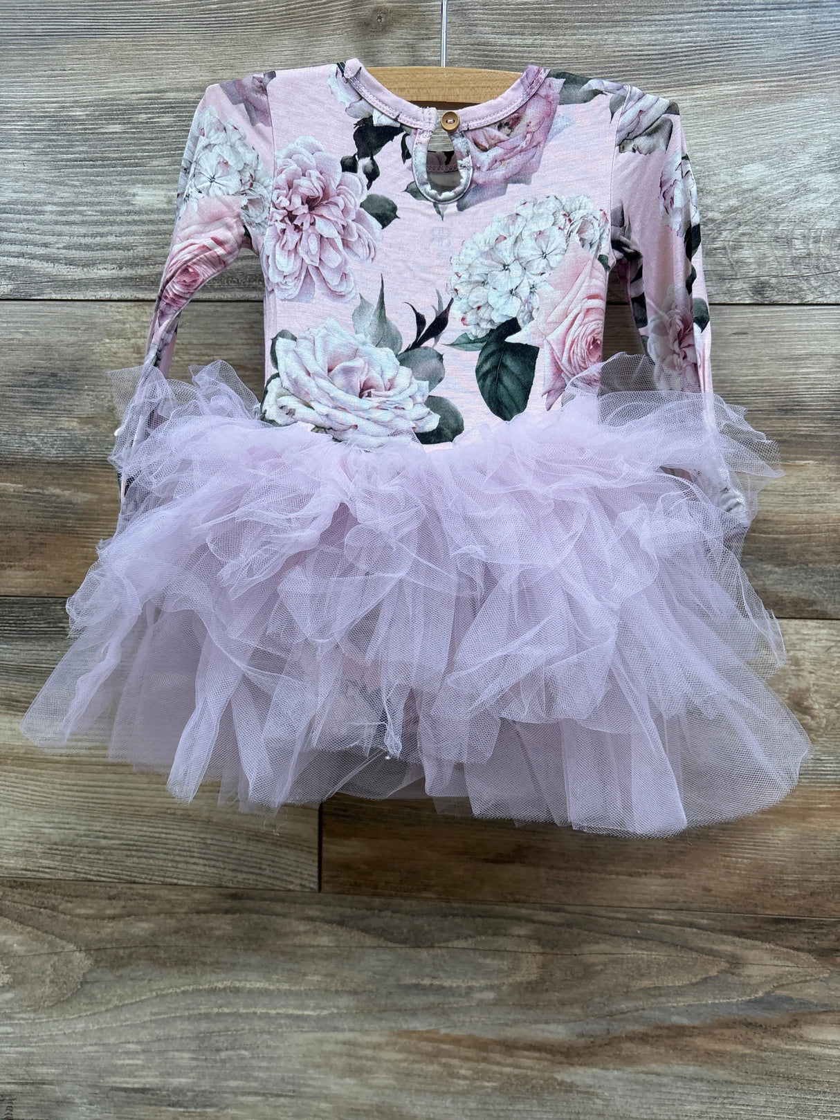 Baby girl's long sleeve floral top with a pink tulle tutu skirt dress on wooden background