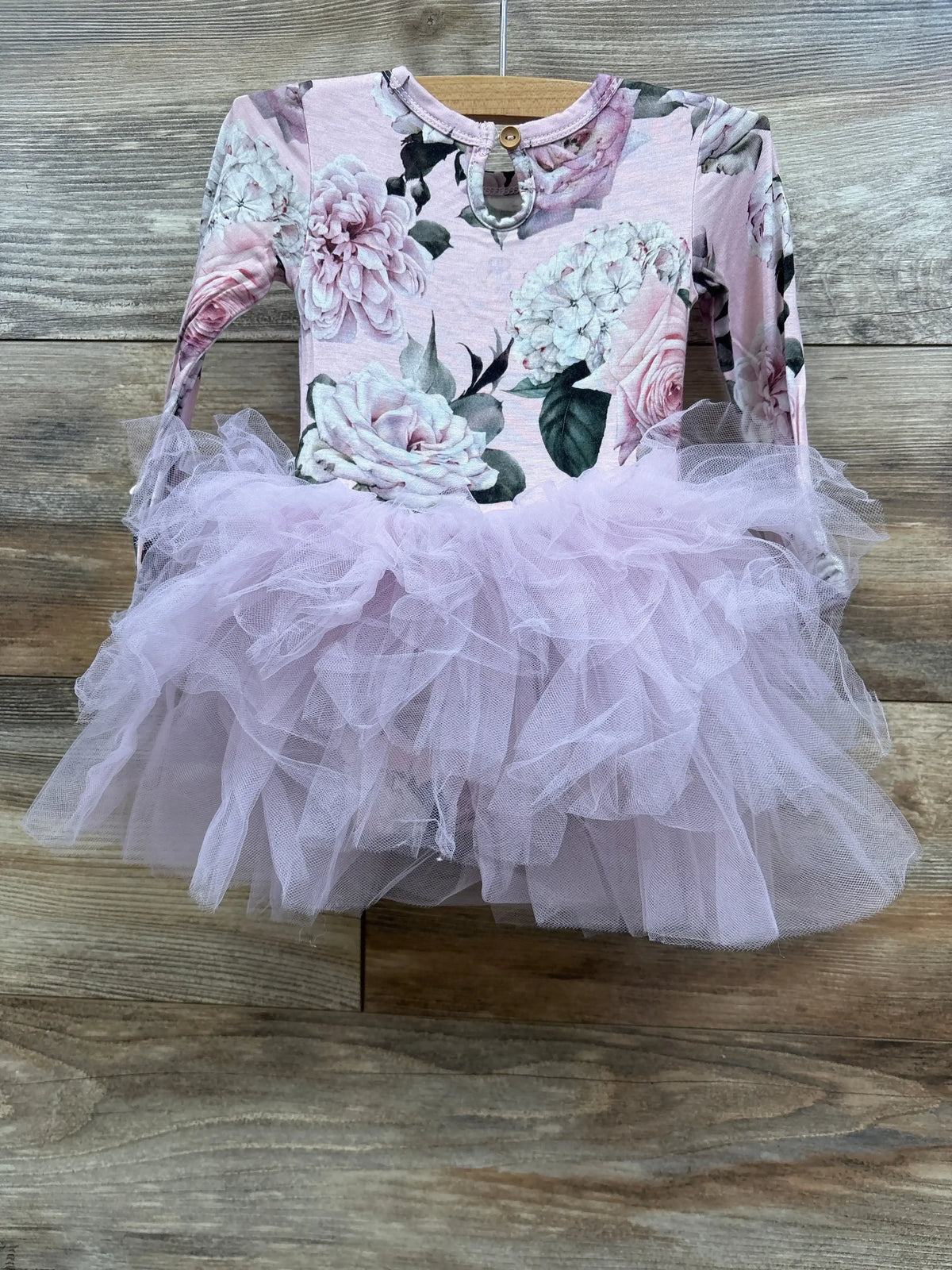 Baby girl's long sleeve floral top with a pink tulle tutu skirt dress on wooden background