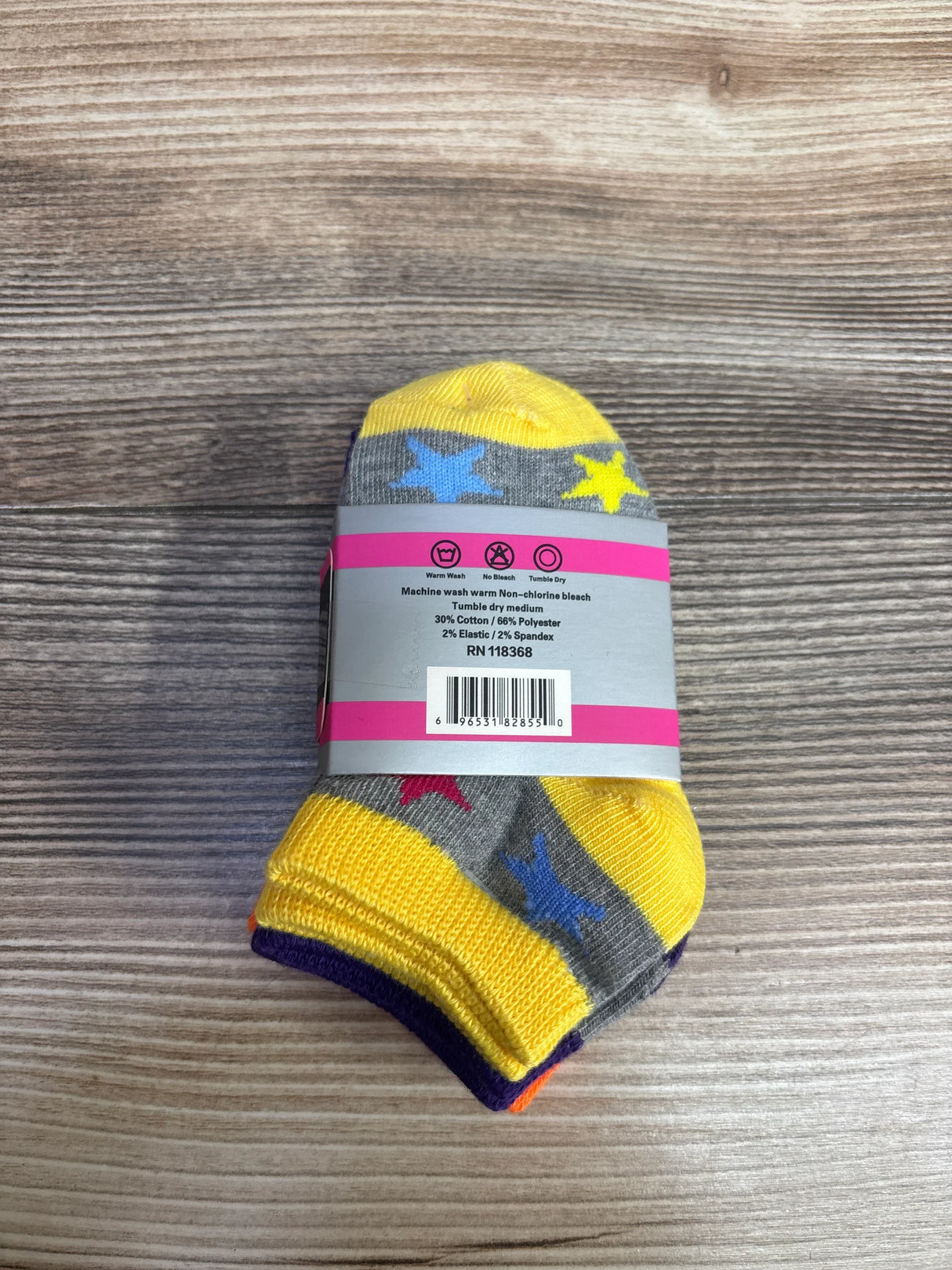 Pack of colorful children's socks with star patterns in yellow, blue, and gray on a wooden surface
