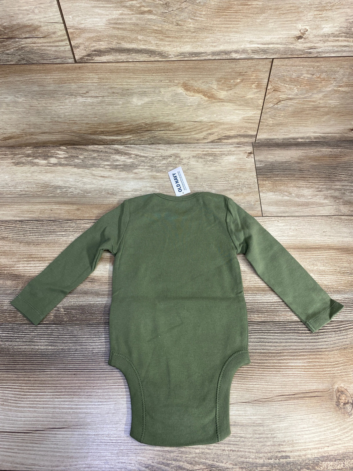 Olive green long sleeve baby bodysuit on wood background, Old Navy tag visible