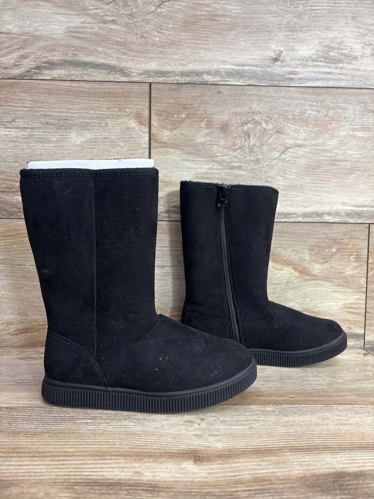Black suede kids winter boots with side zipper on wood background