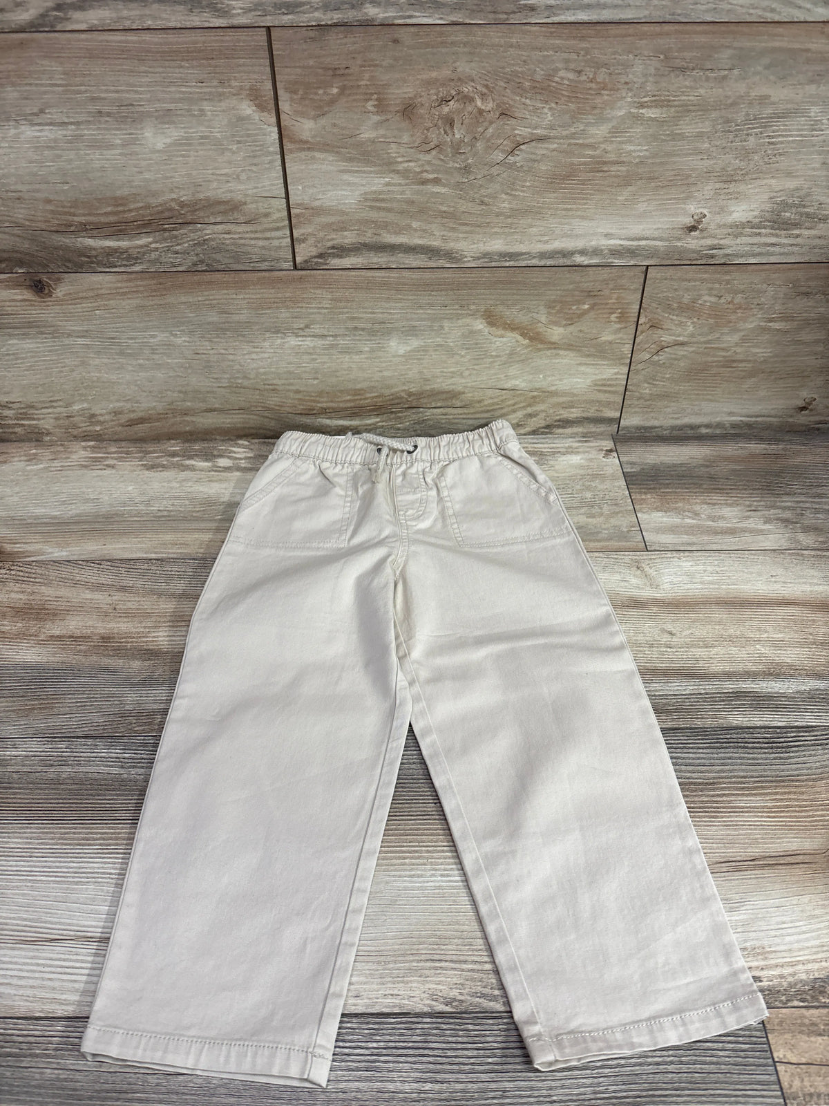 Front view of Cat & Jack beige wide-leg drawstring joggers in size 3T, with elastic waist and front pockets on a wood floor