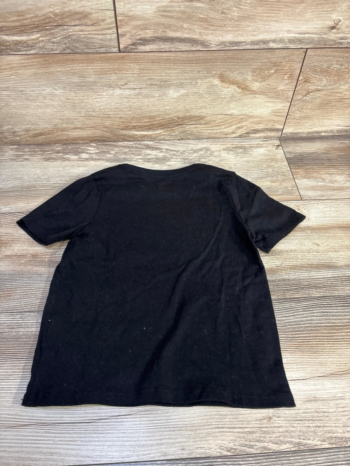 Back view of Way To Celebrate! Halloween Frankenstein shirt in black, showing short sleeves and relaxed fit on a wood-look floor