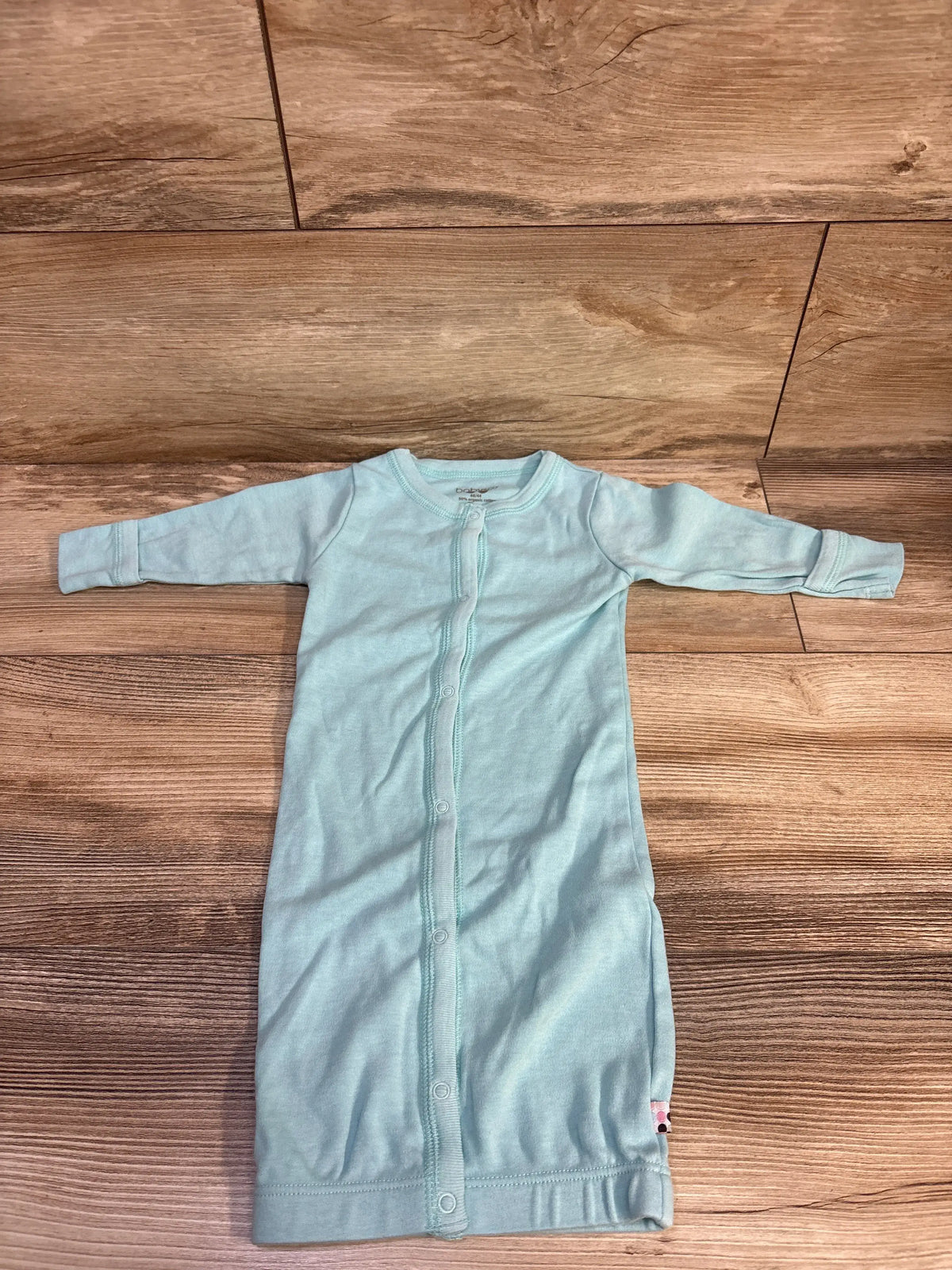 Front view of Babysoy light blue snap-front sleep gown for 3-6 months showcasing center snaps and fold-over sleeve cuffs on wooden floor