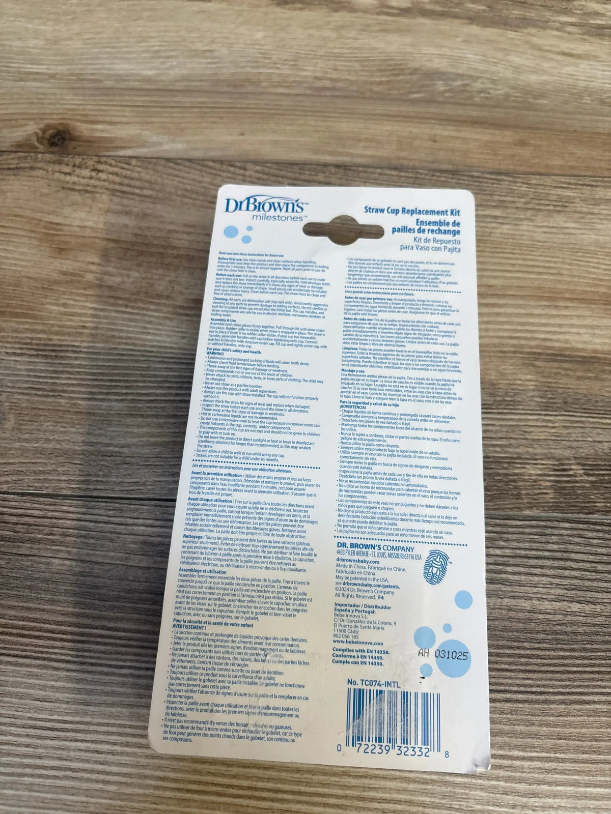 Back view of Dr. Brown's Straw Cup Replacement kit packaging showing care instructions and barcode on wooden surface