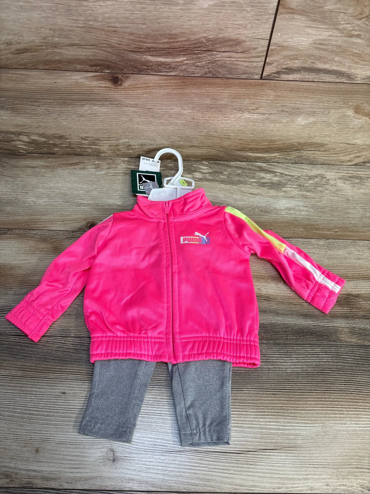 Pink Puma baby tracksuit with gray leggings, full zip jacket, and brand tags on hanger