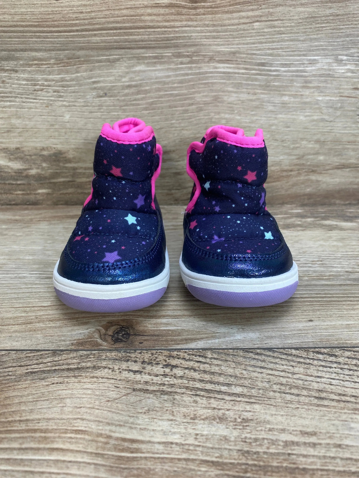 Front view of Surprize By Stride Rite Aster winter boots size 4C, navy star print, hot pink trim, purple soles on wood floor