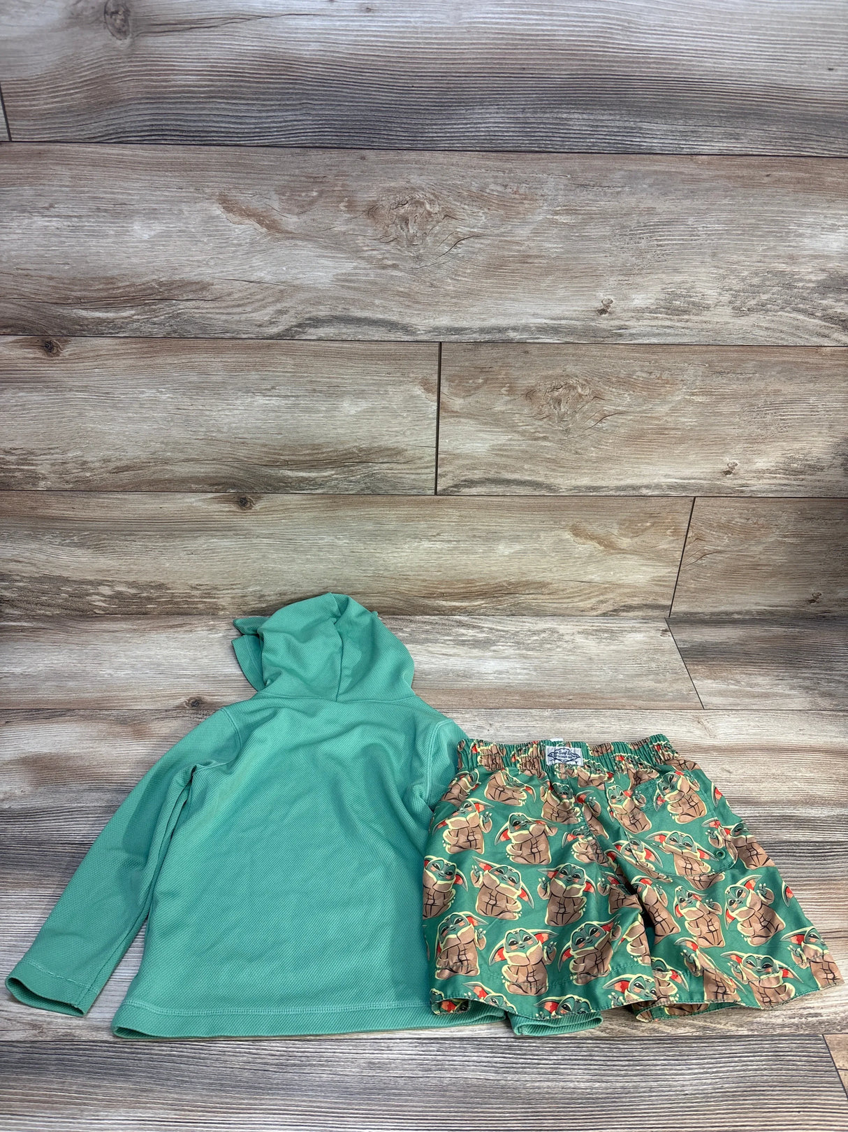 Kids green hooded long sleeve shirt and Baby Yoda print shorts set on wood background
