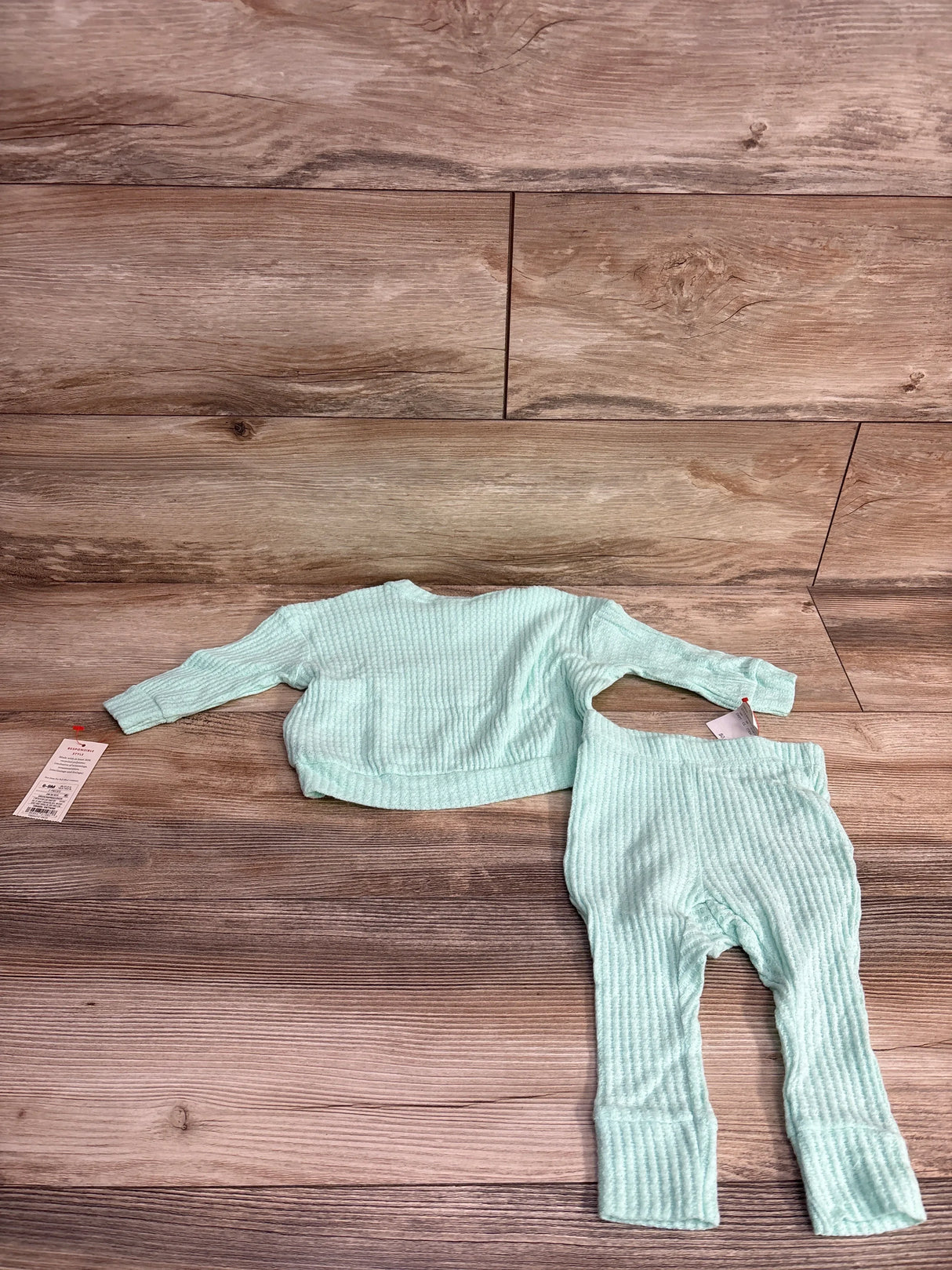Flat lay of Cat & Jack 2-piece waffle knit baby shirt and pants in mint showing waffle texture on wood background