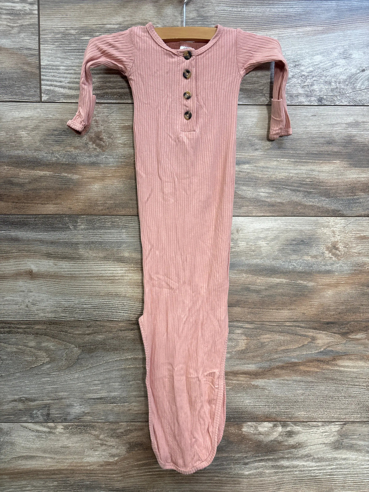 Front view of Lou Lou ribbed henley newborn gown showcasing coral color, button front, and long sleeves on wood background