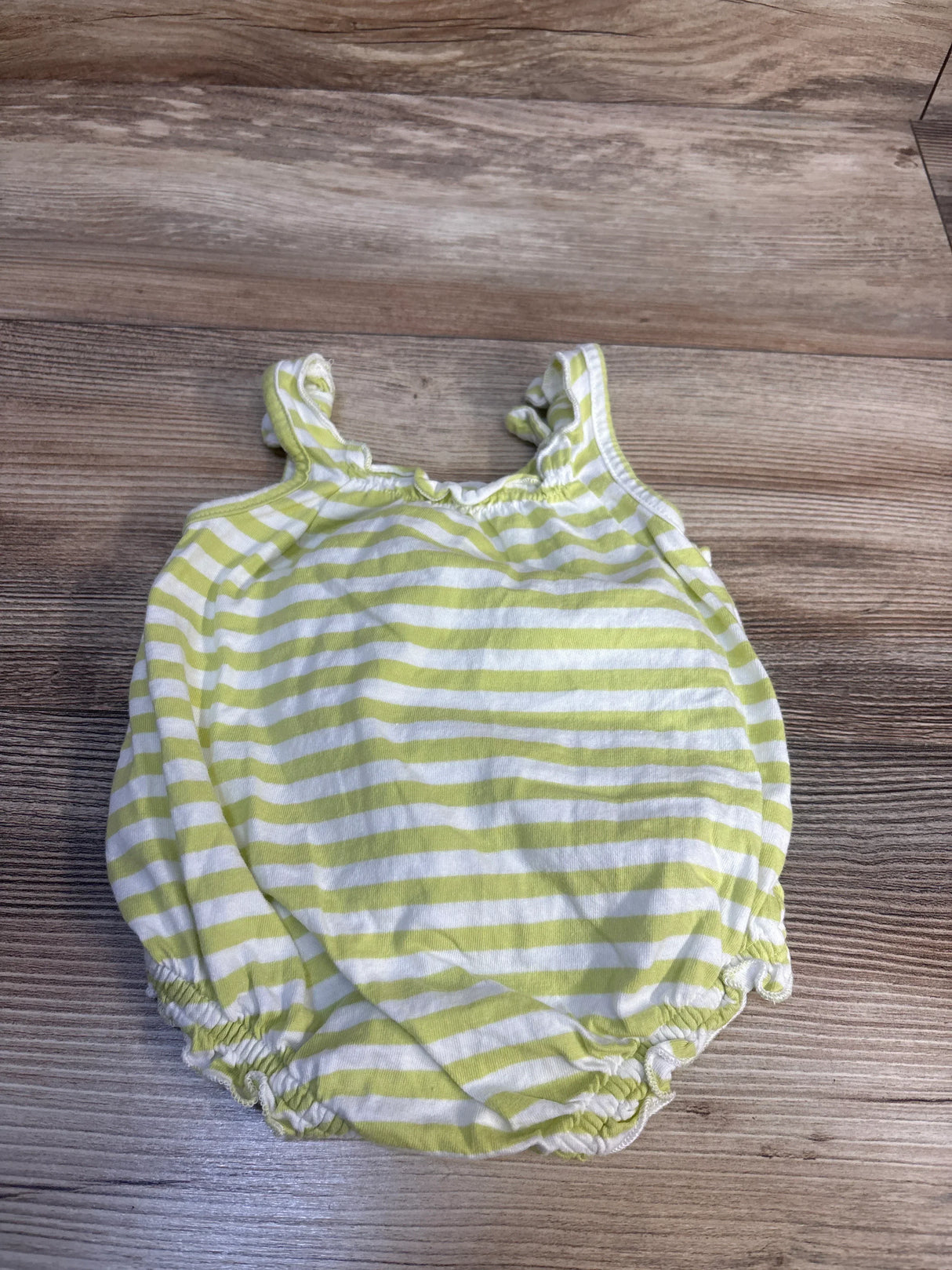 Flat lay of Old Navy green and white striped bubble romper showing ruffled shoulder straps and elasticized leg openings on wood background