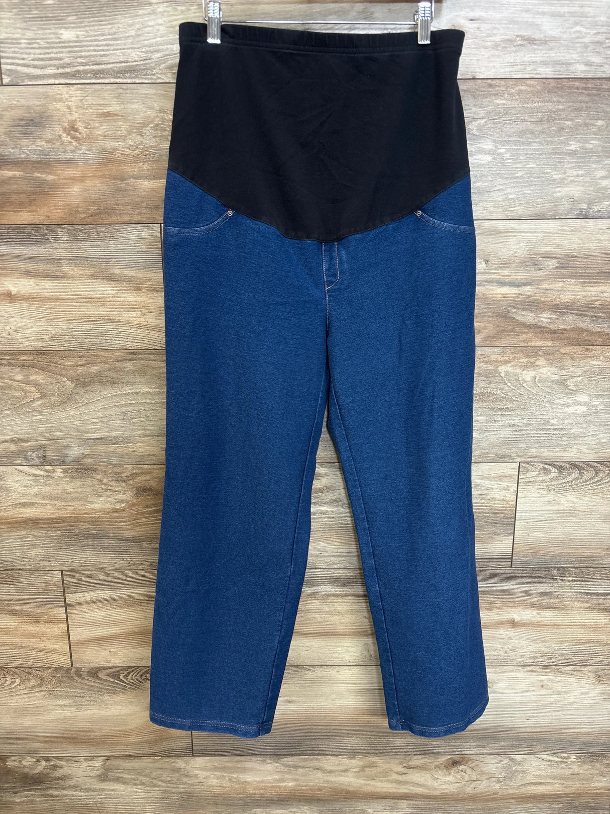 Front view of Time and Tru maternity jeans showing black belly panel and straight leg blue denim on wood background