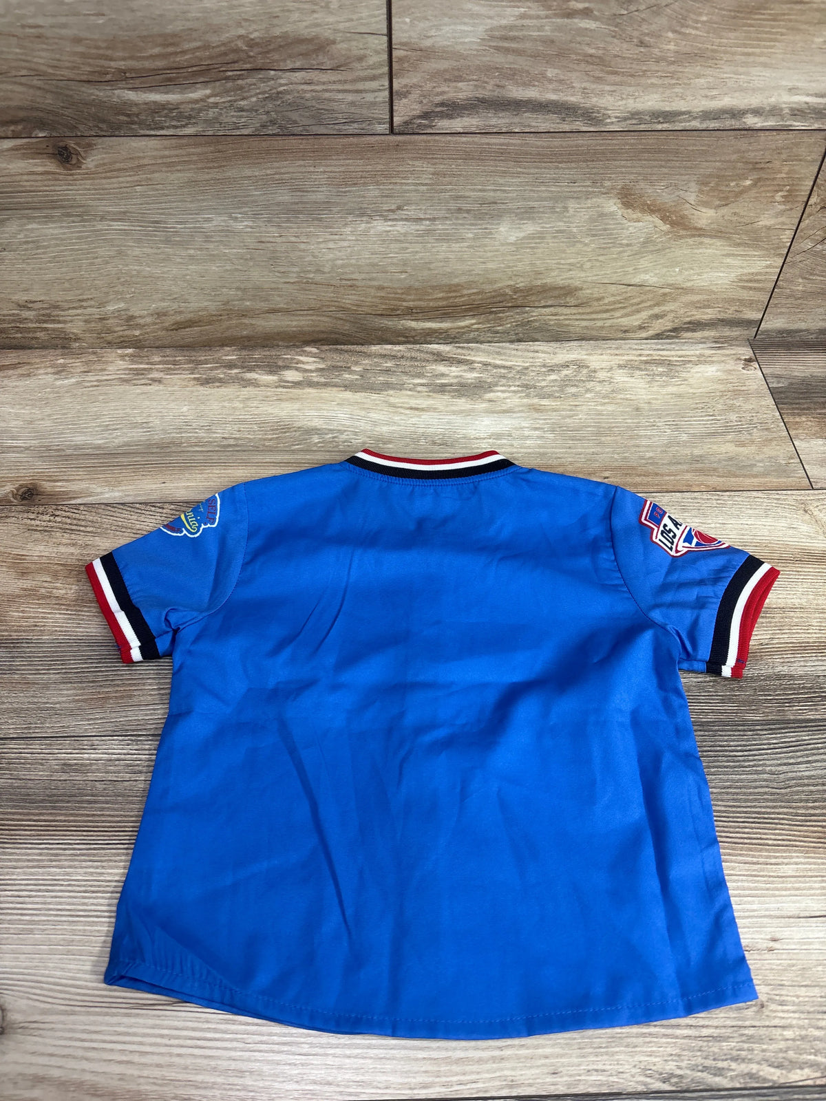 Back view of Shein California blue baseball jersey shirt in size 3T showcasing striped cuffs on a wood-look floor