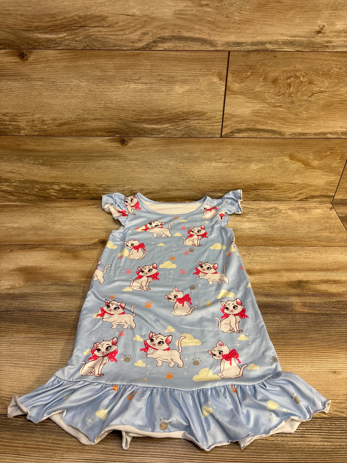 Flat lay of blue Disney Aristocats Marie toddler nightgown size 3/4T showing ruffle hem and flutter sleeves on wood background