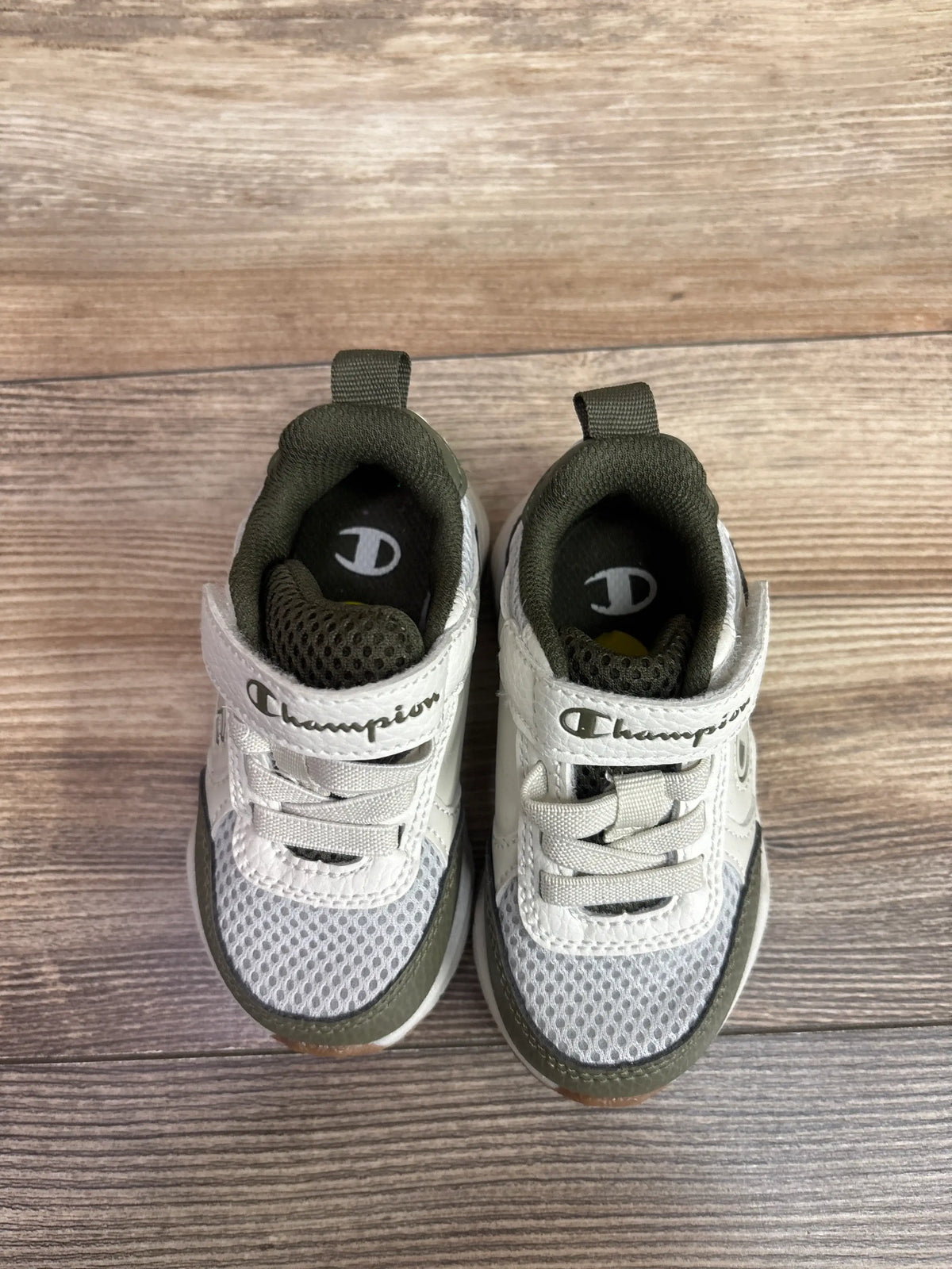 Top view of Champion Hyper V2 Next sneakers, size 5C, in white and green, showcasing mesh uppers and laces on wood flooring
