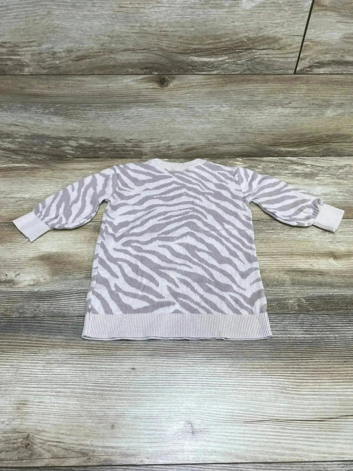 Flat lay of Baby Gap tiger-stripe sweater dress, size 12–18M, showing long sleeves and ribbed hem on wood background