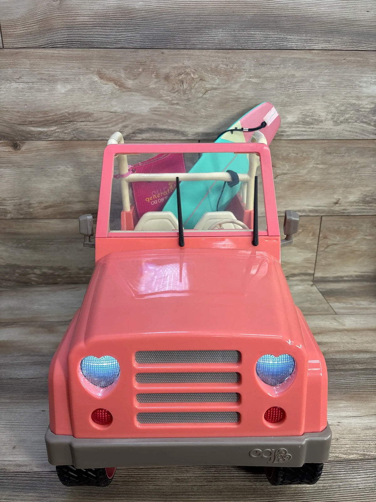Our Generation Off-Roader 4x4 doll vehicle in pink with a teal surfboard