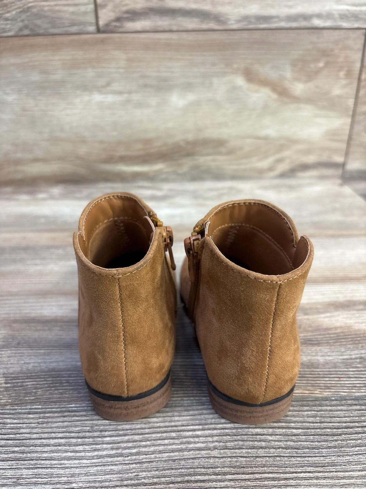 Rear view of Cat & Jack Penelope boots in brown showcasing side zippers with a tiled floor background