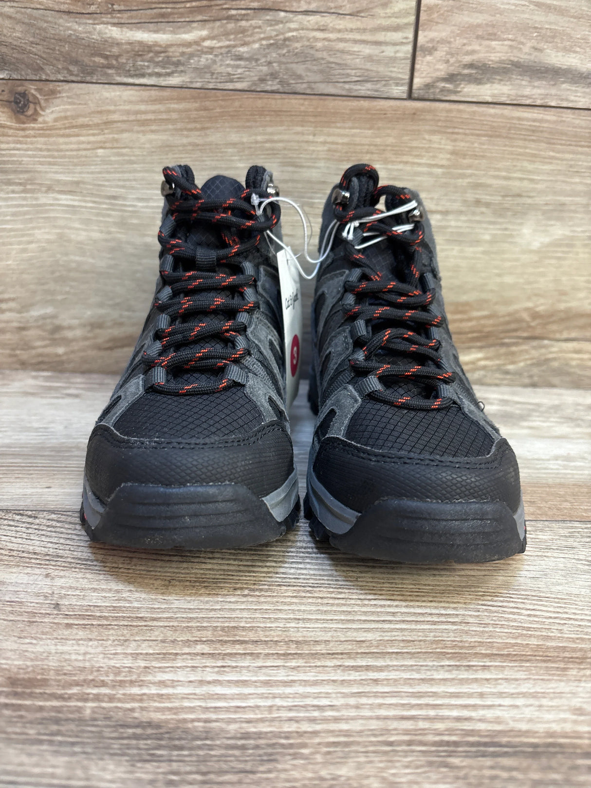 Front view of Cat and Jack Patsy hiking boots size 3Y, black and gray with red accented laces on wood floor