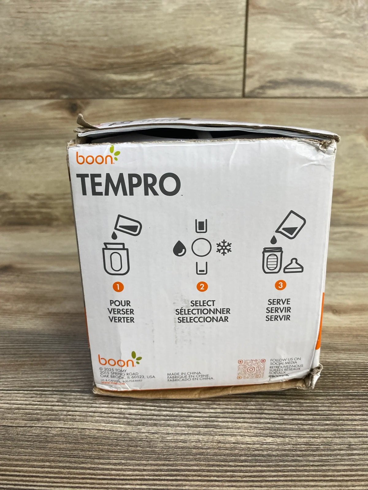 Front view of Boon Tempro direct heat breastmilk warmer box showcasing step icons for Pour, Select, Serve with a wood surface background