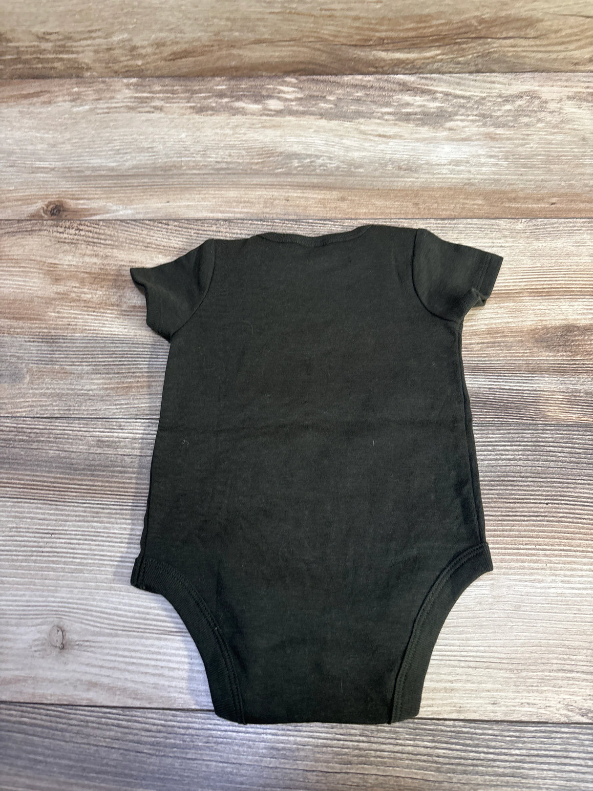 Back view of green short-sleeve baby bodysuit showcasing crew neck, size 0-3 months, laid flat on wood background