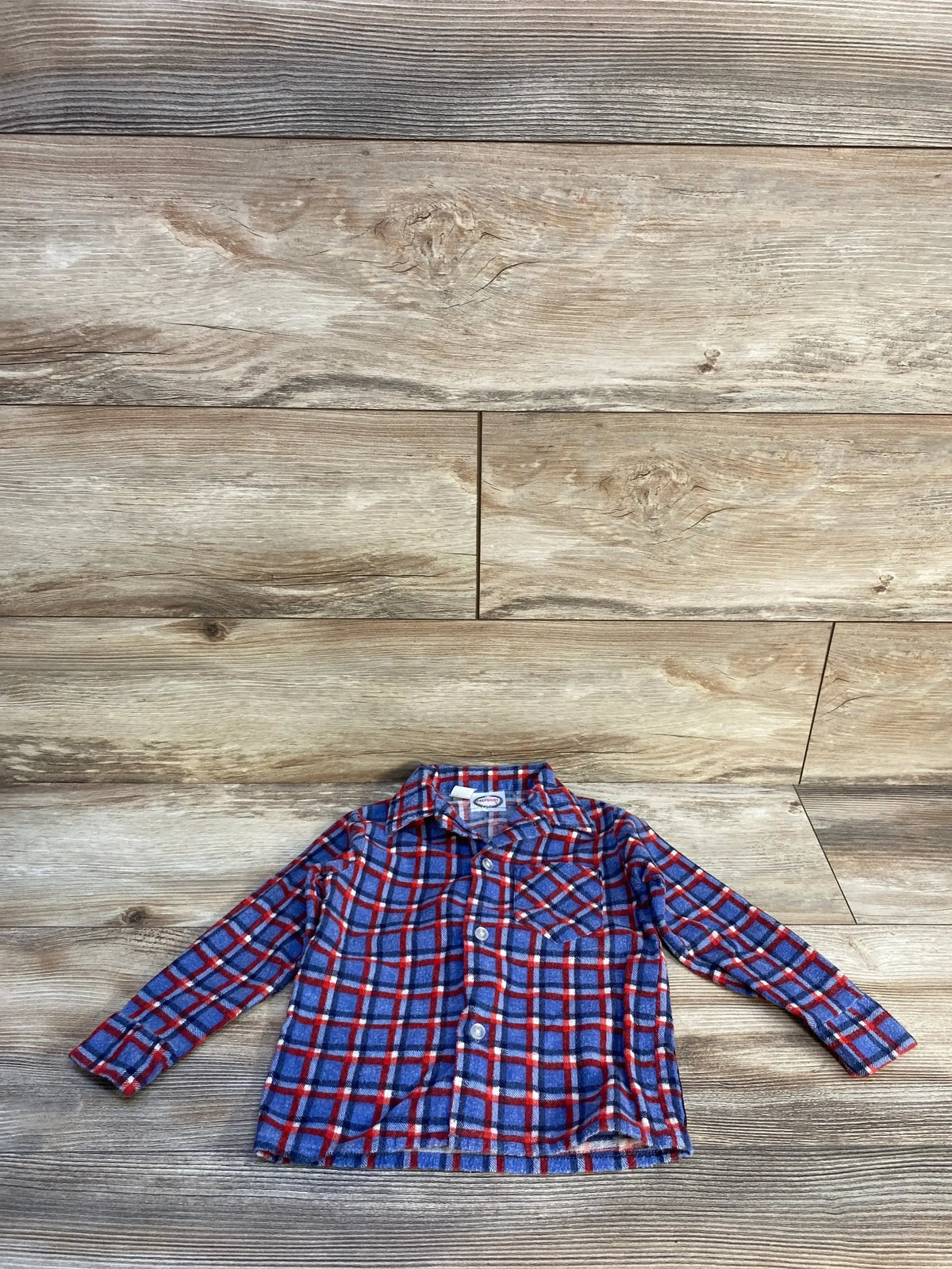 Blue and red plaid long-sleeve button-up toddler shirt on wooden floor background