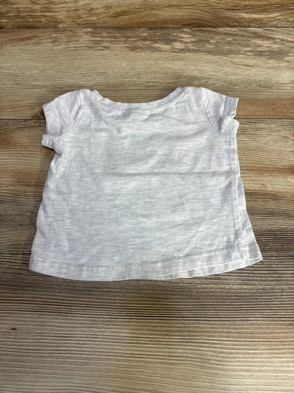 Back view of grey Puma baby T-shirt (size 6–9 months) showcasing short sleeves and heathered fabric with wood background