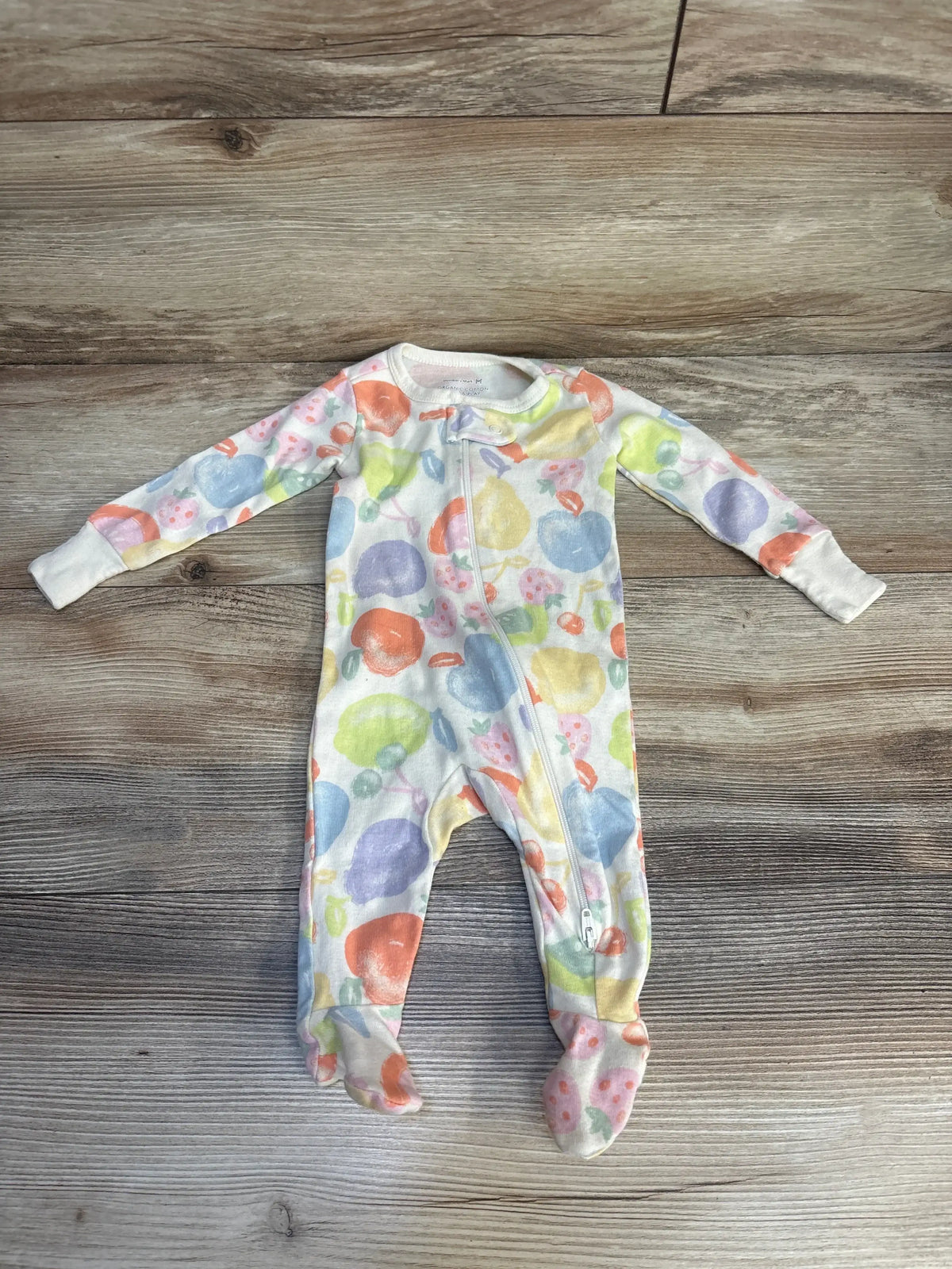 Colorful fruit print baby sleeper with zipper on wood background, long sleeves and footed design