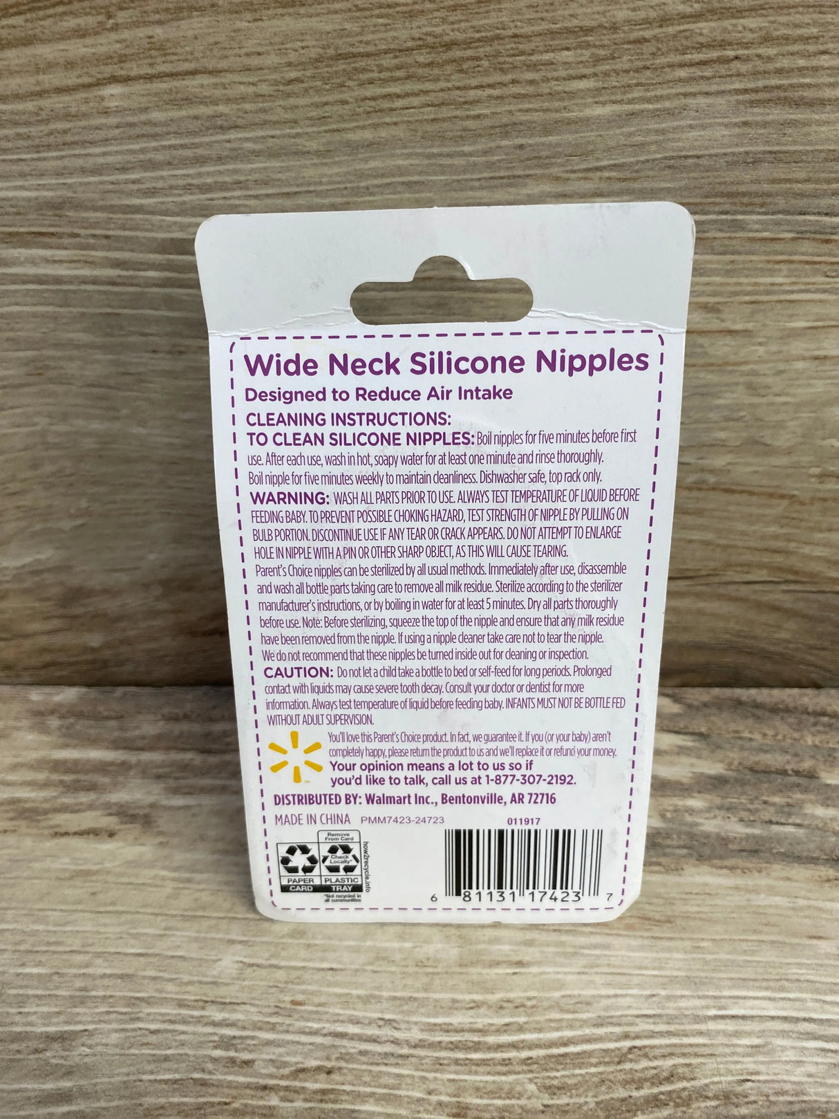 Back of Parent's Choice 3pc wide-neck silicone nipples packaging showing headline and cleaning instructions on wood