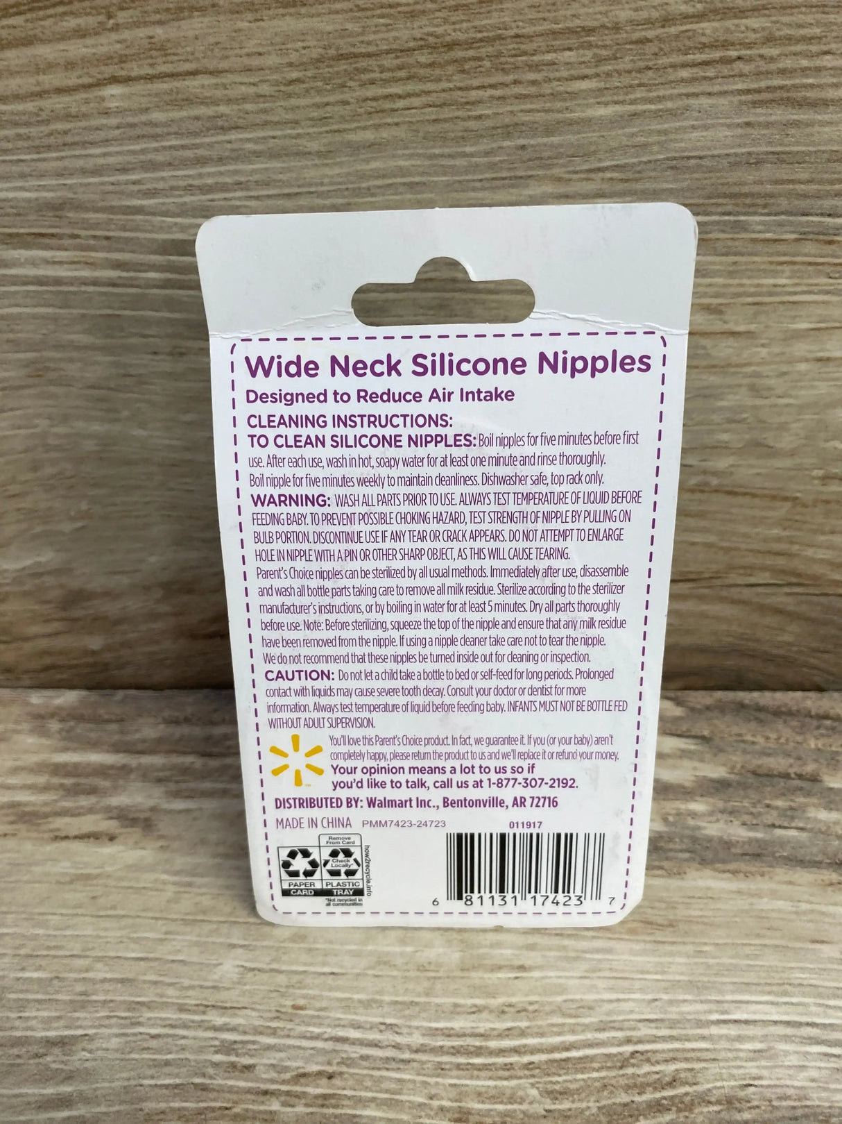 Back of Parent's Choice 3pc wide-neck silicone nipples packaging showing headline and cleaning instructions on wood