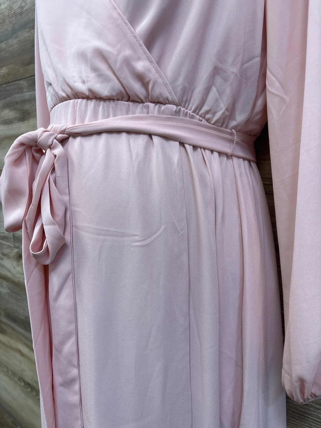 Soft pink maternity dress with wrap top, elastic waist, and tie belt for comfortable pregnancy wear.