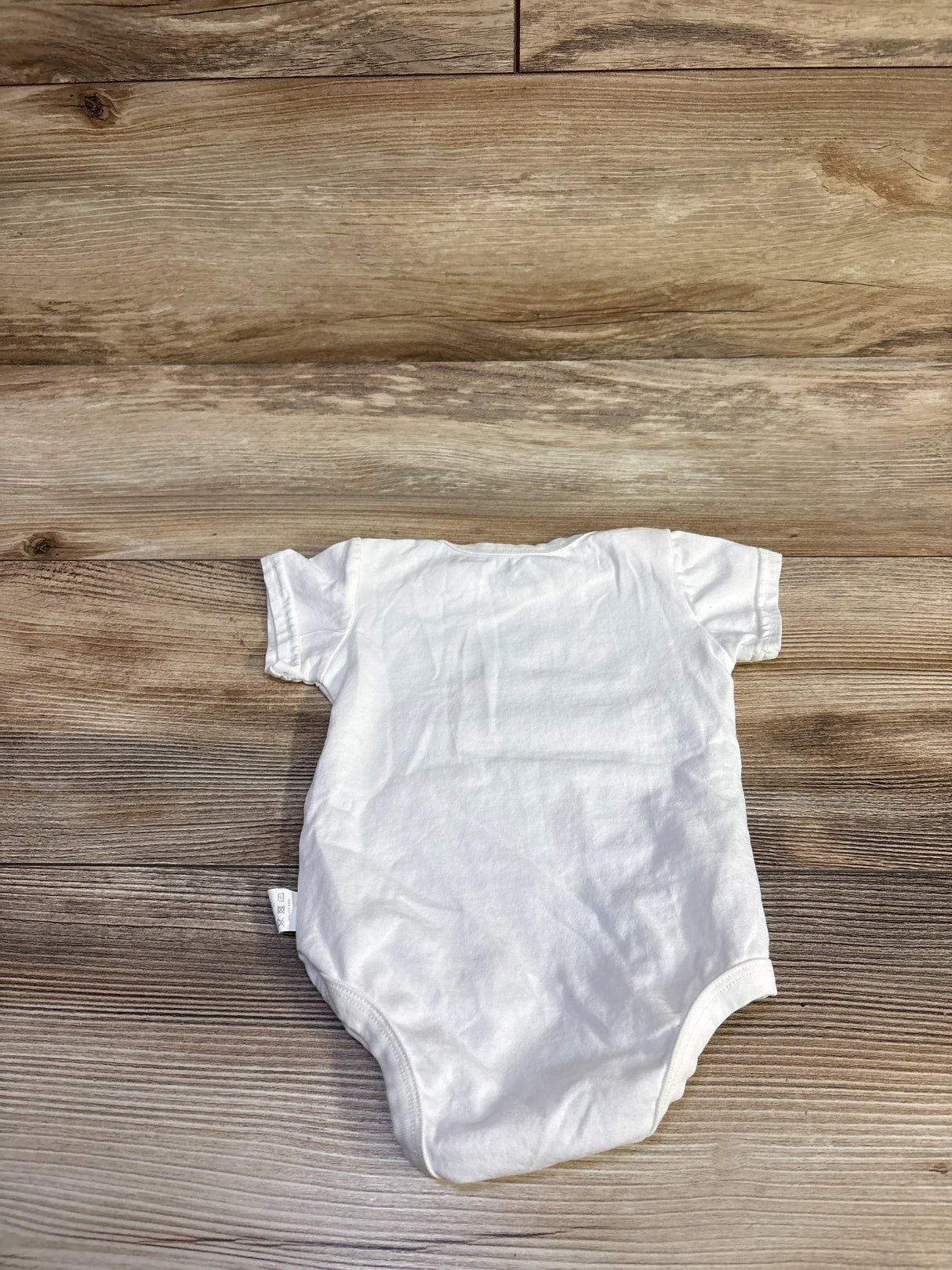 Back view of BFUStyle white baby bodysuit showcasing short sleeves and plain back on wood floor