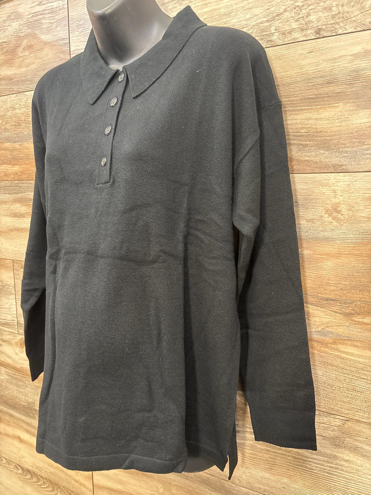 Black long-sleeve maternity polo shirt on mannequin against wooden background