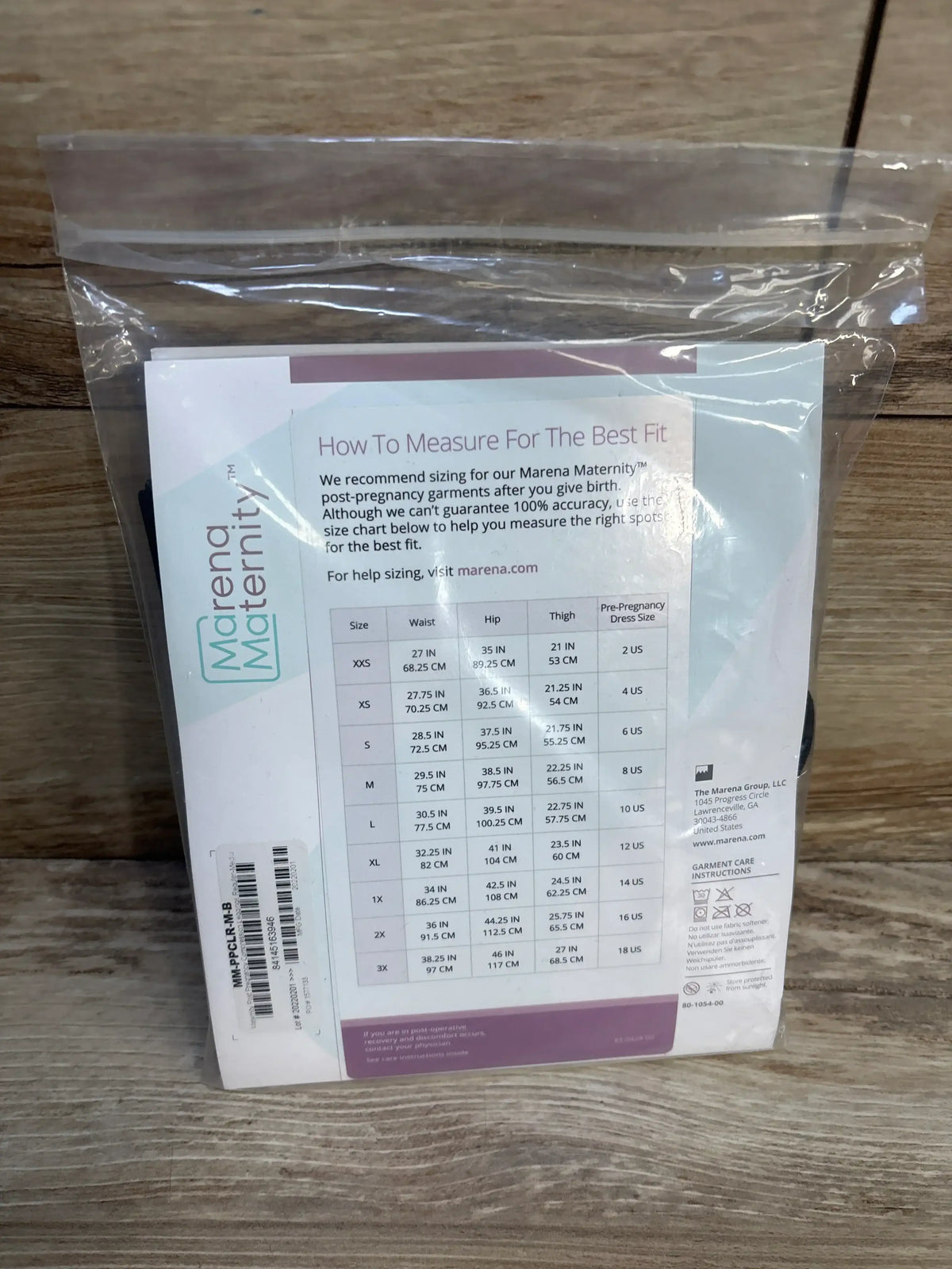 Back of Marena Maternity post-compression leggings package showing size chart with waist, hip and thigh measurements on wood
