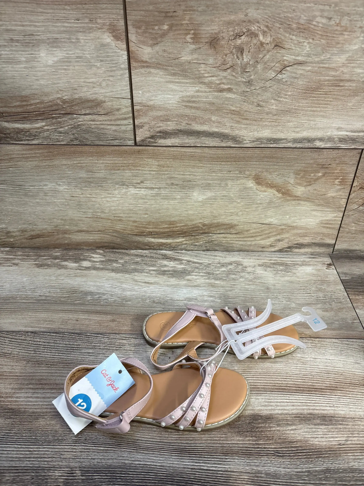 Top-down view of Cat & Jack toddler pearl-strap sandals in blush showing ankle strap and decorative pearls on wood floor