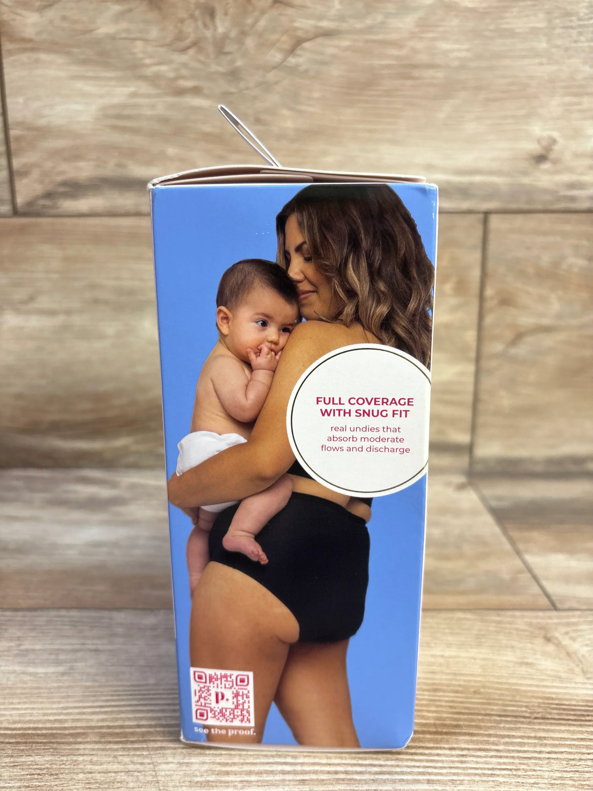 Side of NEW Proof Reusable Postpartum Underwear High Rise Brief sz Large box showcasing mother and baby with full coverage snug fit callout on wood plank floor