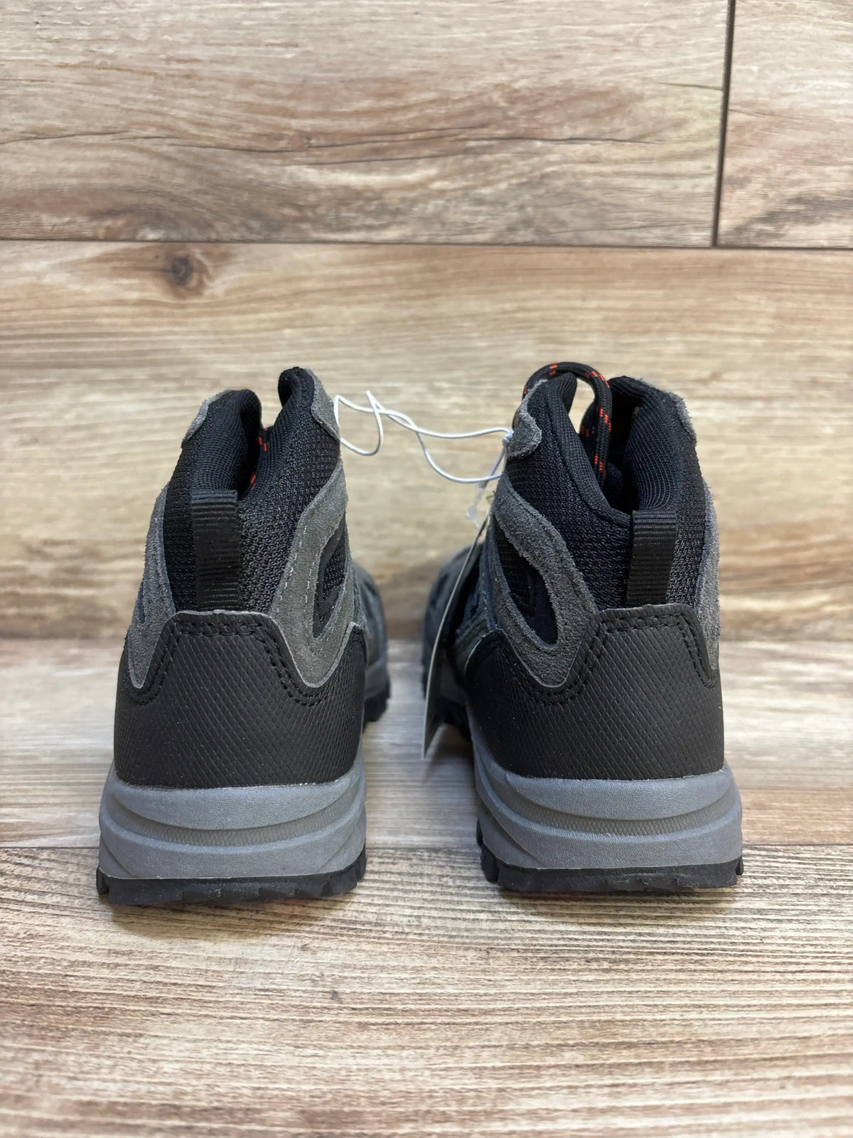 Rear view of Cat and Jack Patsy hiking boots in black and gray showing pull tabs, padded collars and tread on wood floor
