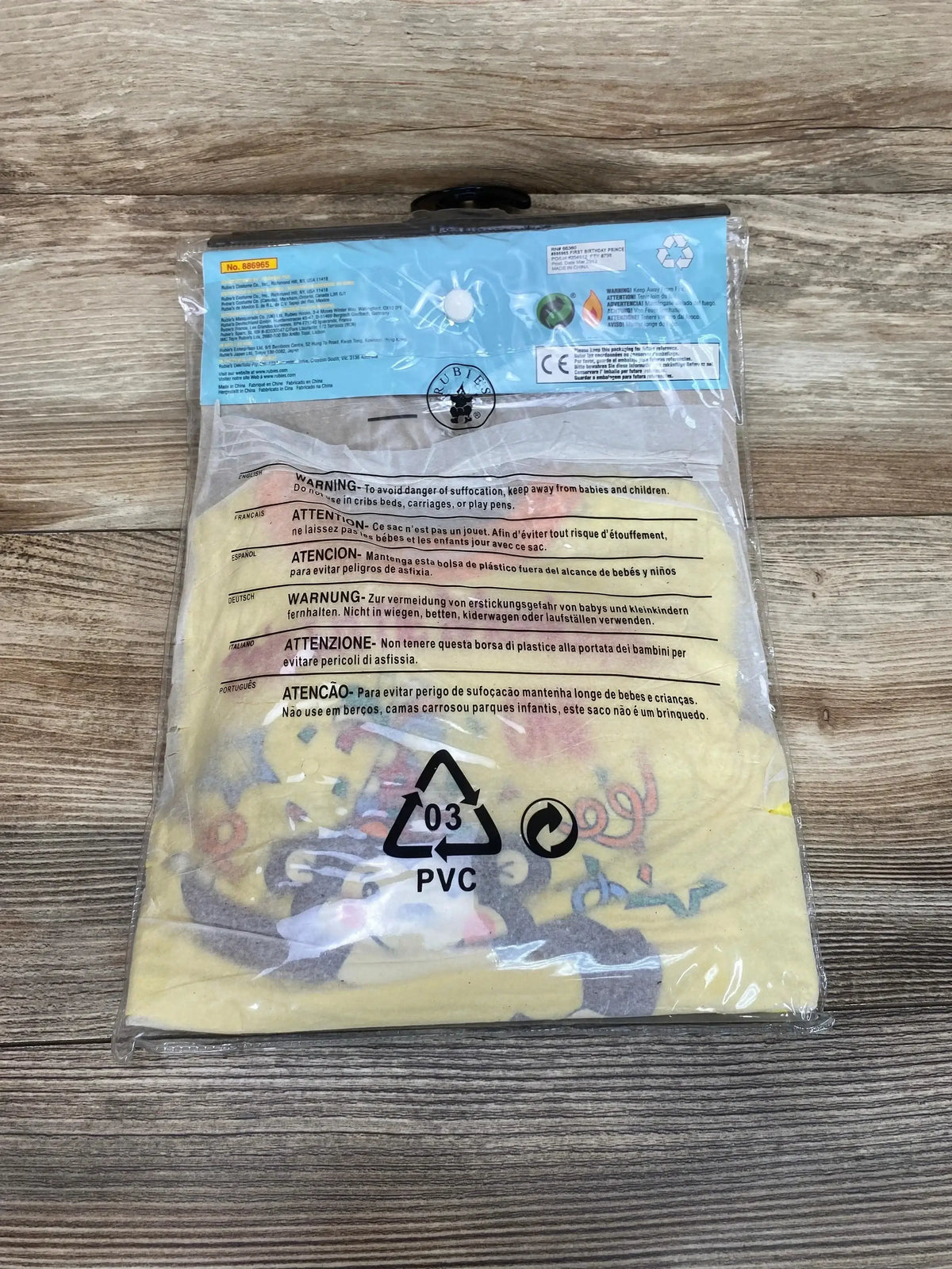 Back view of Rubie’s NEW 1st Birthday Monkey Costume, size 6-12 months, in clear packaging on a wood tabletop