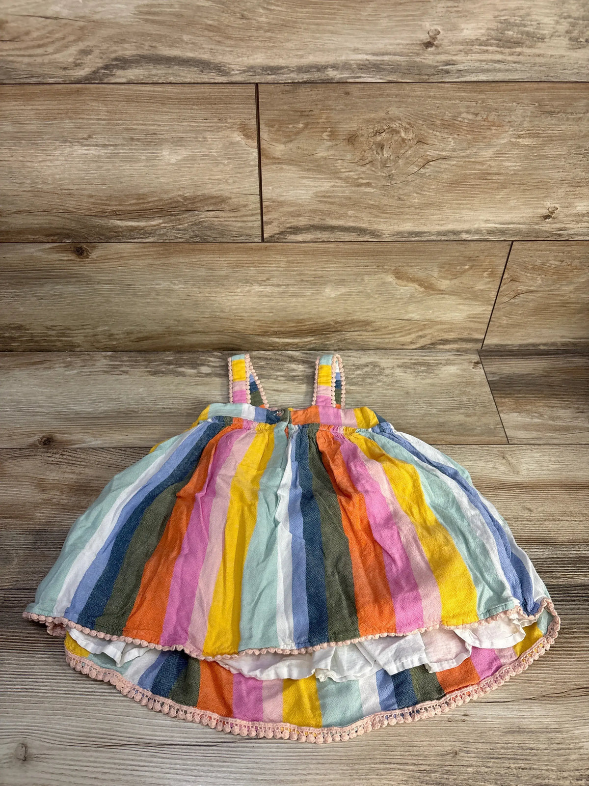 Front view of Tahari striped tank dress showcasing multicolor vertical stripes and tank straps with a wood-grain background