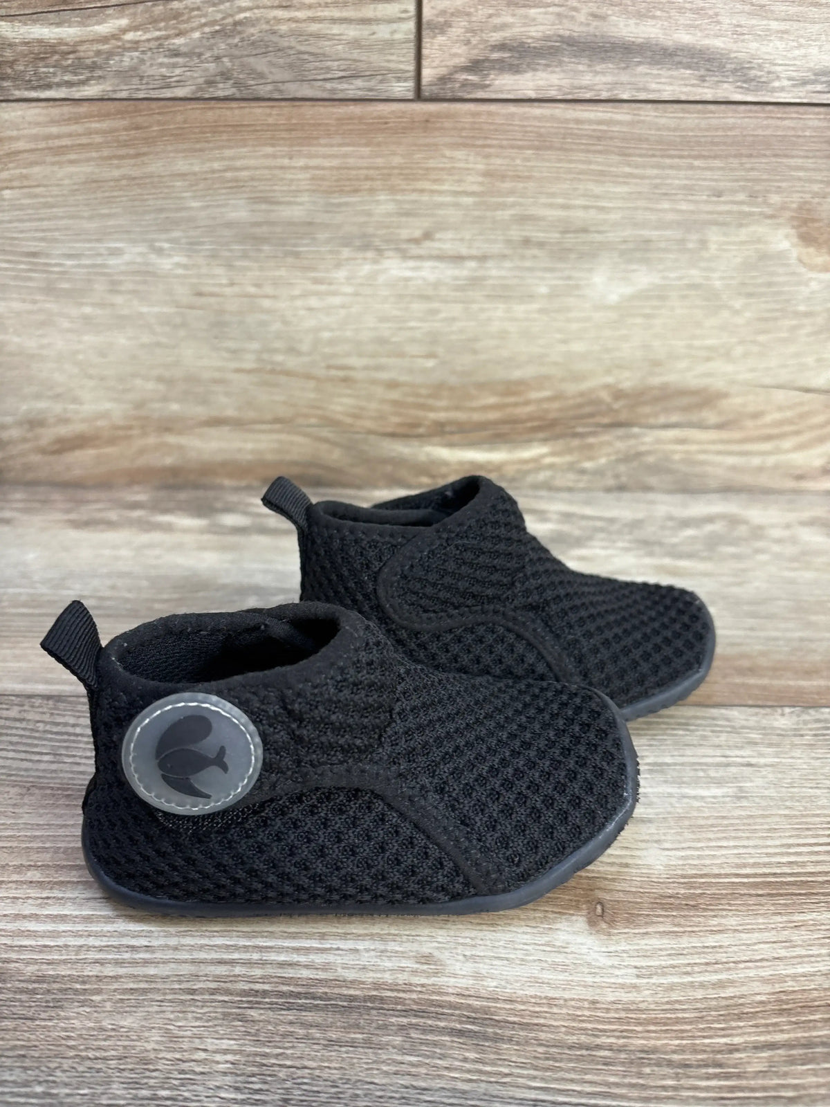 Pair of black FEETCITY high-top mesh sock shoes for toddlers on a wooden background.