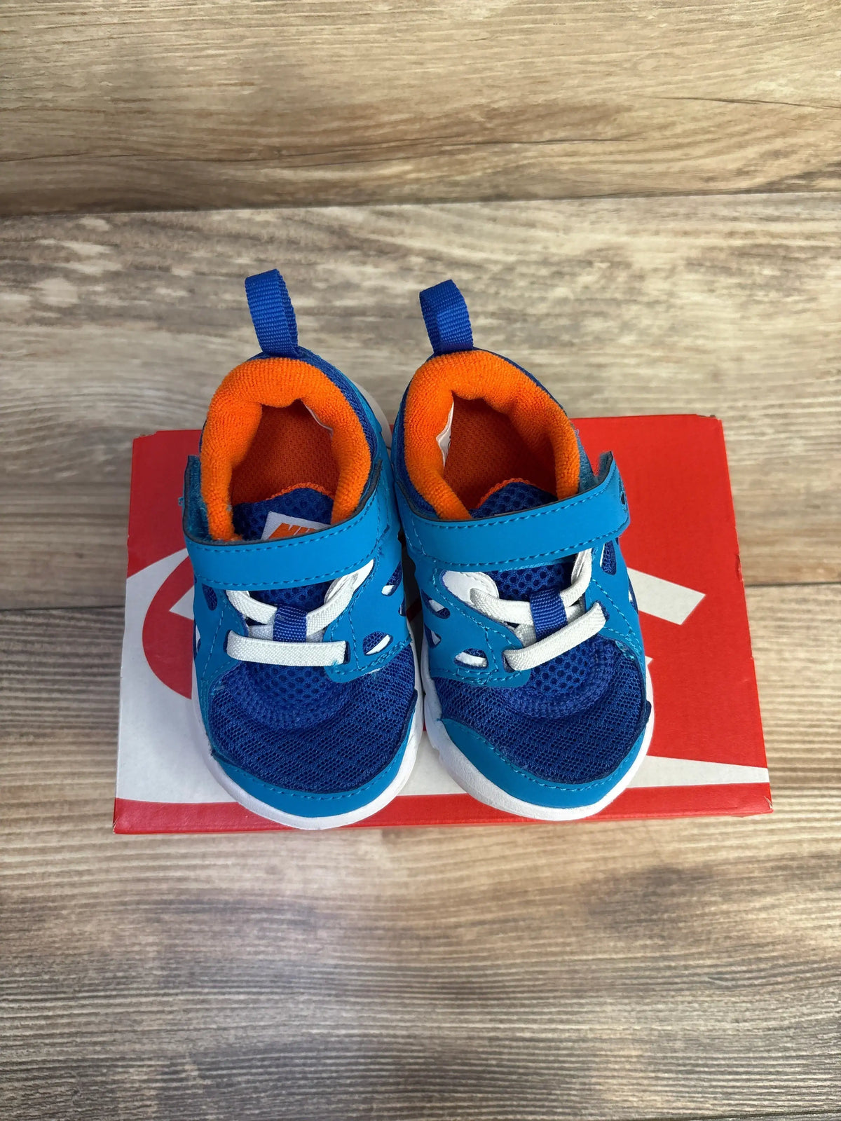 Angled side view of toddler Nike Free Run 2 blue sneakers showcasing mesh upper and flexible sole on white background