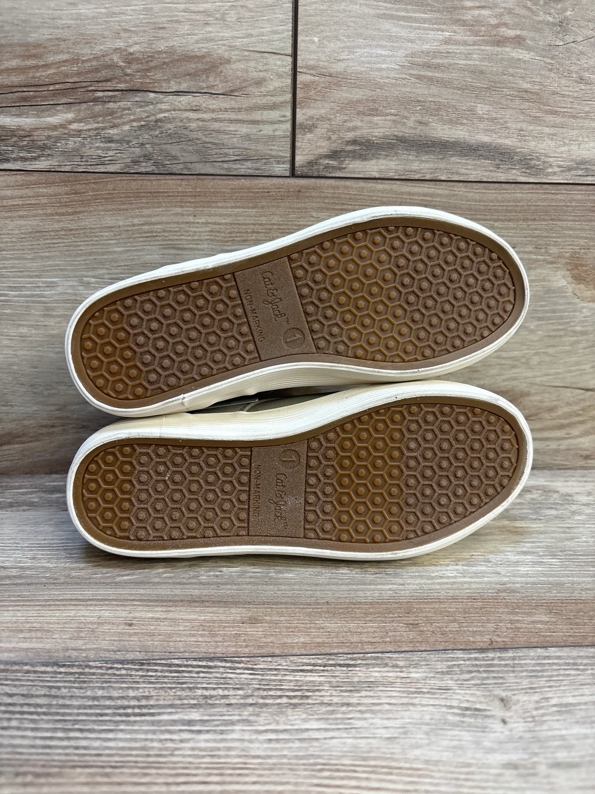 Pair of Cat & Jack kids shoes with honeycomb tread soles on wood floor