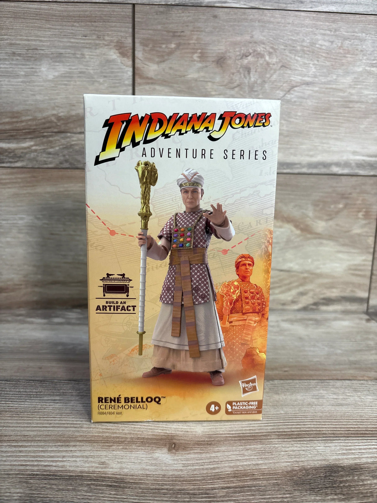 Front view of Indiana Jones Adventure Series René Belloq action figure in box showing ceremonial robes and staff on wood background