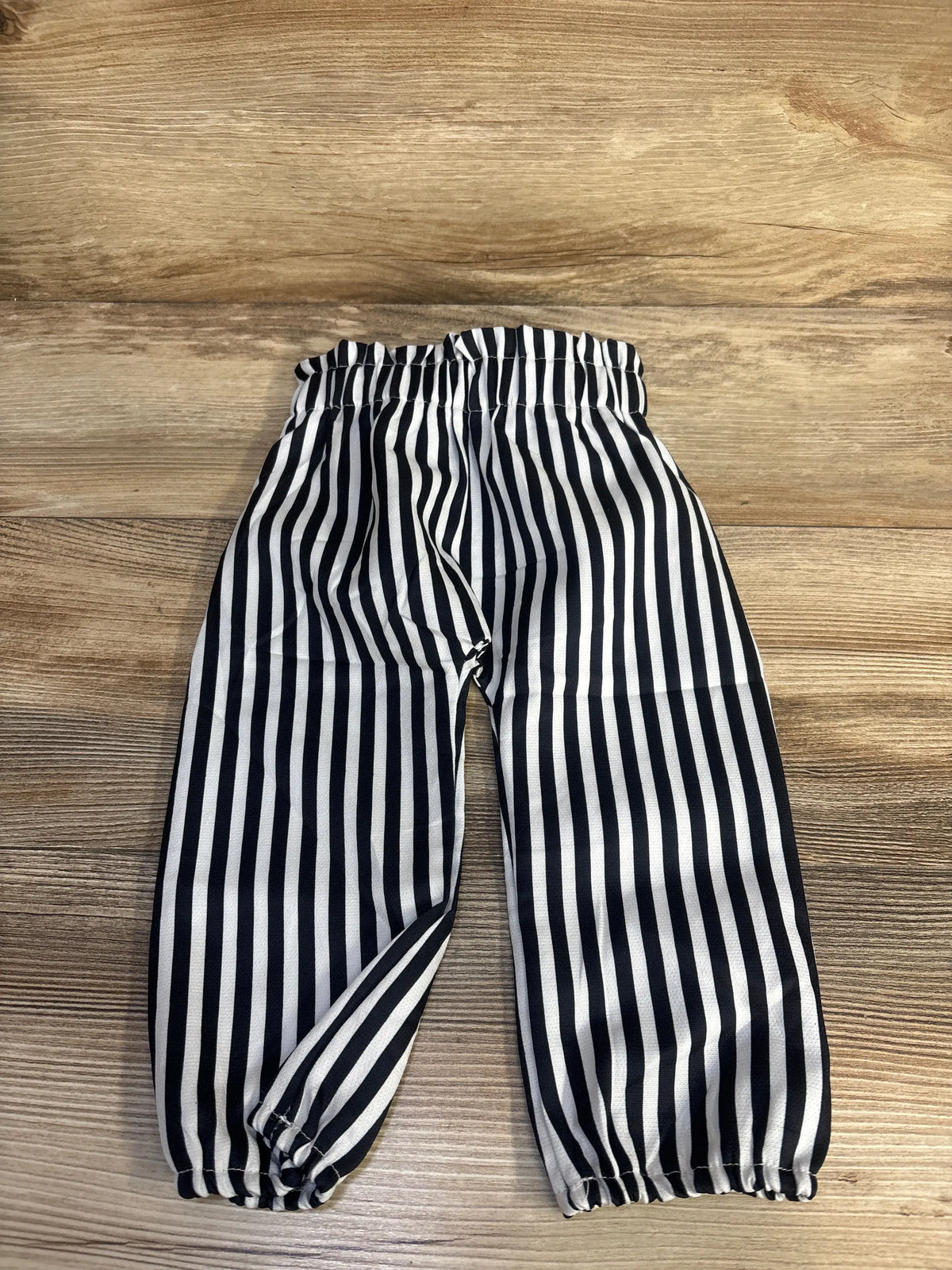 Front view of white striped pull-on pants showcasing elastic waistband and gathered cuffs for size 18 to 24 months on a wood surface