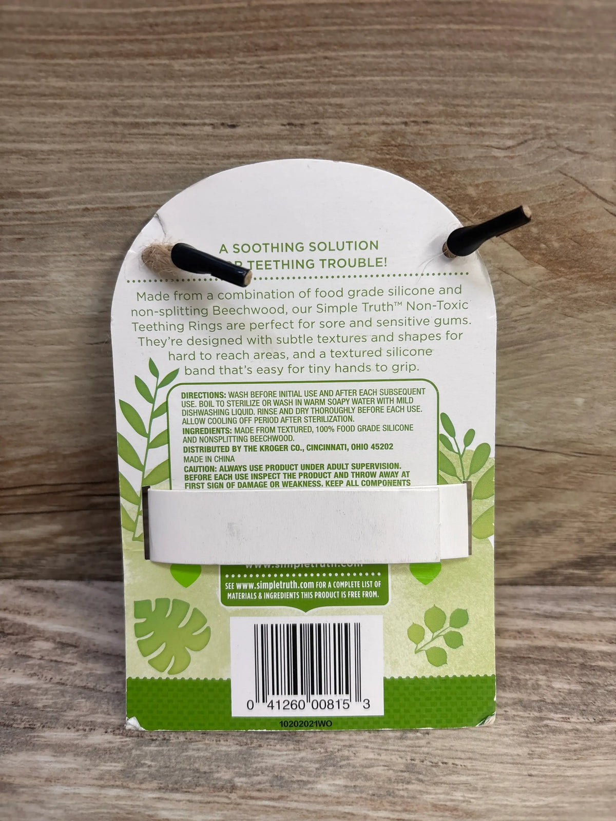 Back view of Simple Truth teal koala teething ring packaging showing A soothing solution to teething trouble on a wood surface